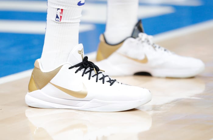 White and gold Nike Kobe 5 shoes.